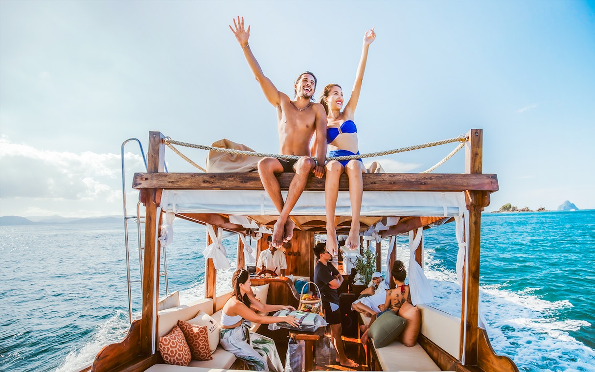Luxury longtail boat cruise at sunset in Krabi with people relaxing.