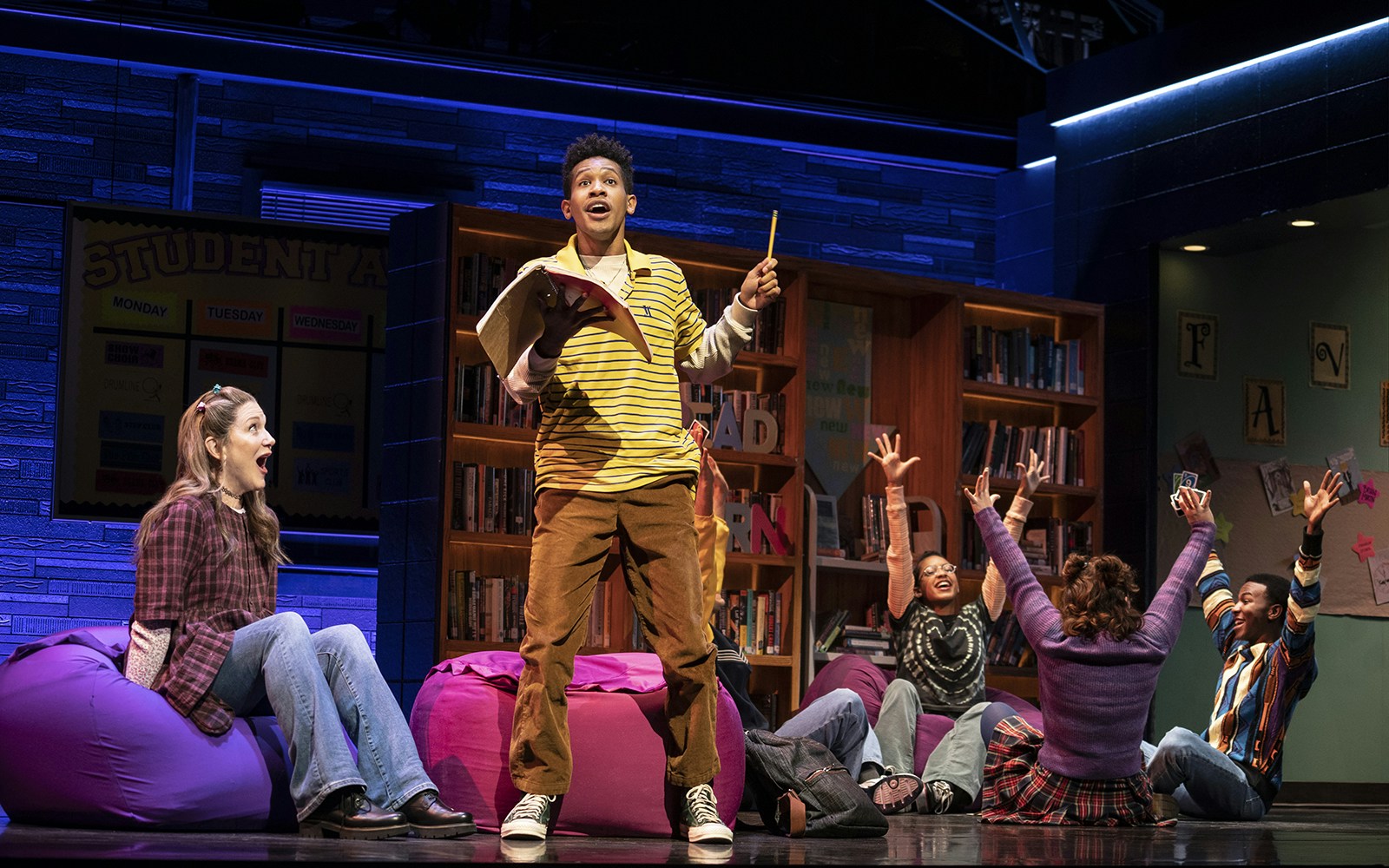 Students performing a lively scene in the musical Kimberly Akimbo, set in a library.