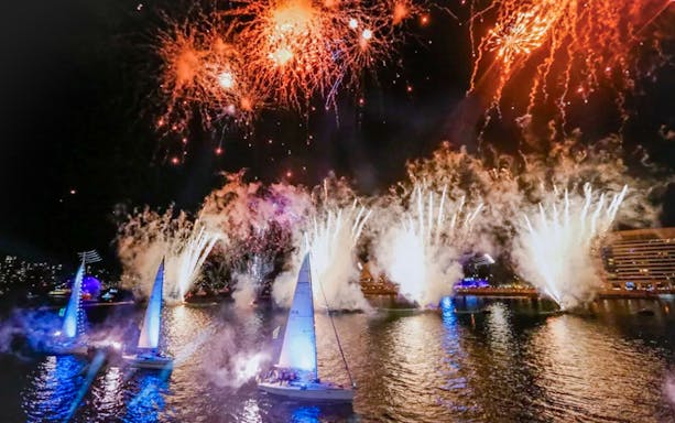 Sailboats on Sydney Harbour with fireworks during Australia Day cruise.