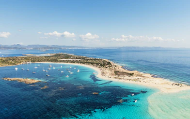 Aerial view of Ibiza island coastline with boats during Formentera Cruise Tour.
