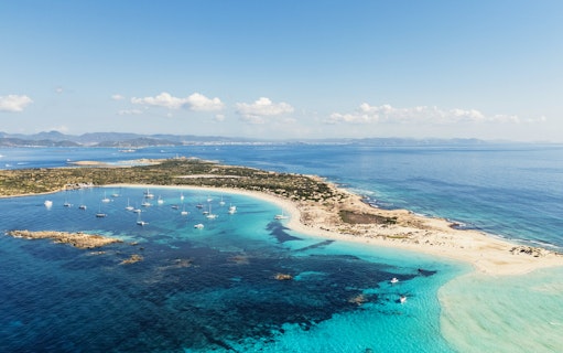Aerial view of Ibiza island coastline with boats during Formentera Cruise Tour.