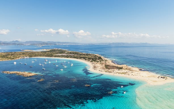 Aerial view of Ibiza island coastline with boats during Formentera Cruise Tour.