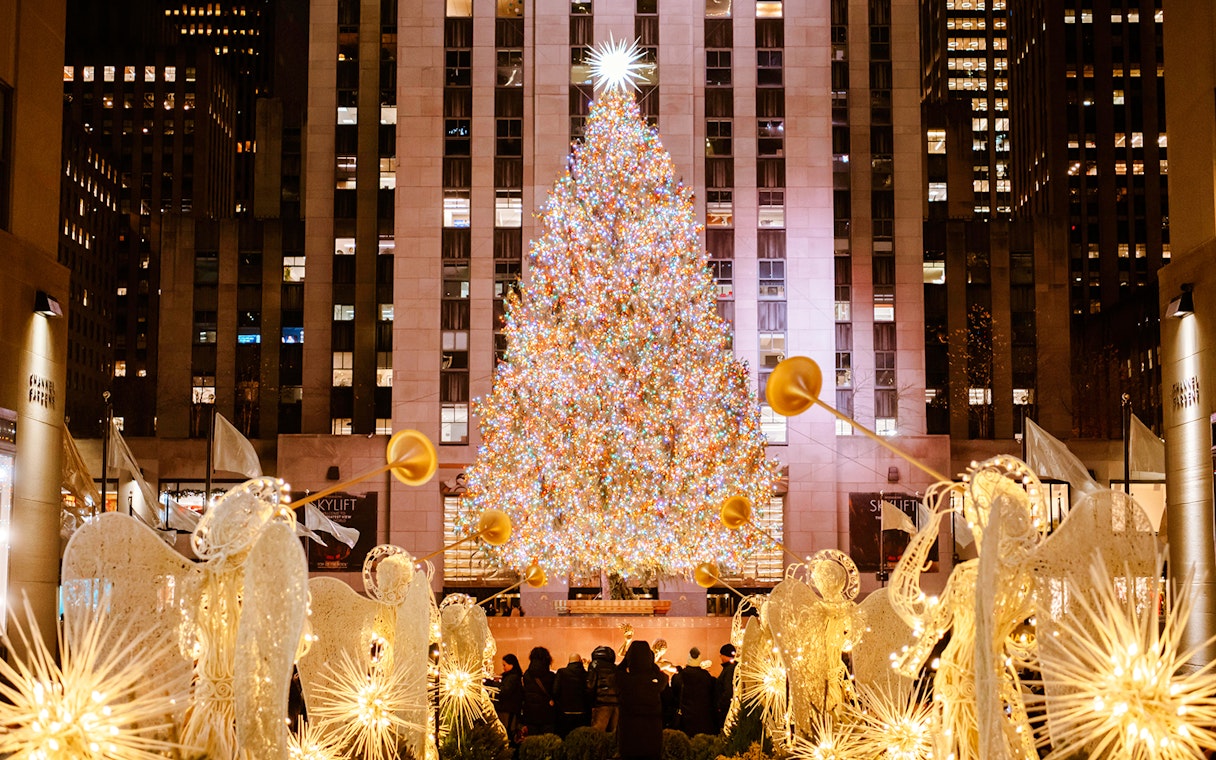 Rockefeller Center Christmas tree with holiday lights and angel decorations in New York City.