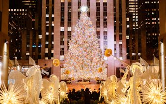 Rockefeller Center Christmas tree with holiday lights and angel decorations in New York City.