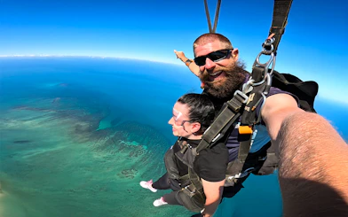 Tandem skydive over Great Barrier Reef, Cairns, with clear blue skies.