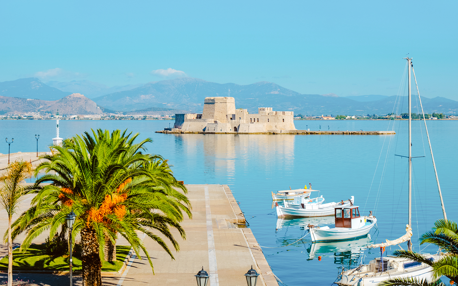 Nafplio port with boats and Bourtzi Castle in Greece.