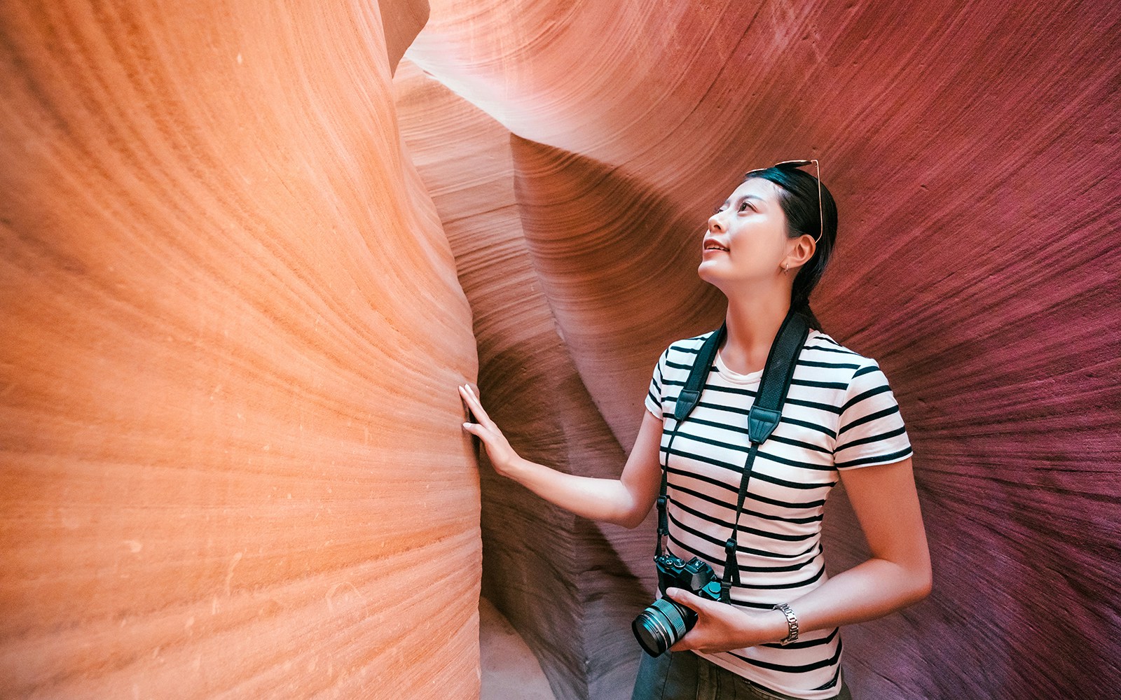 Tourist exploring the narrow sandstone walls of Antelope Canyon X.