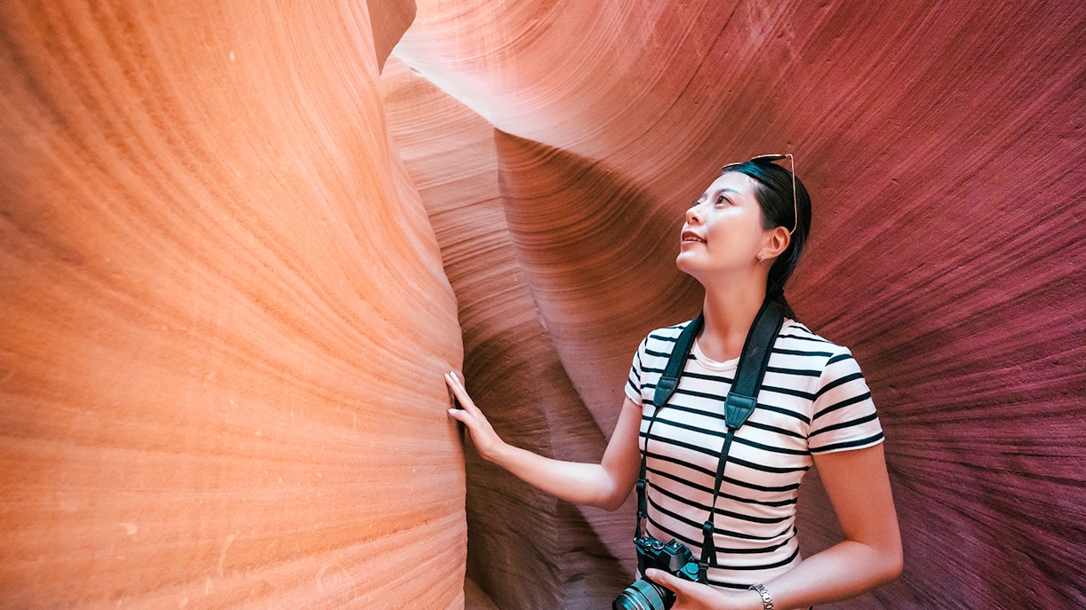 Tourist exploring the narrow sandstone walls of Antelope Canyon X.