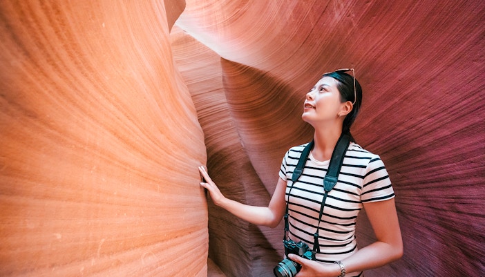 Tourist exploring the narrow sandstone walls of Antelope Canyon X.