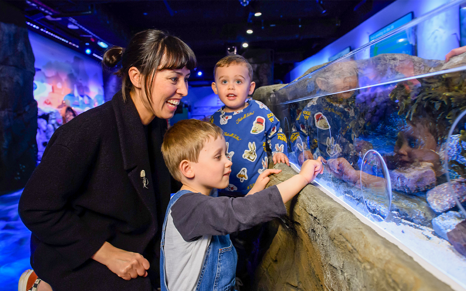 Family exploring SEA LIFE London aquarium exhibit.