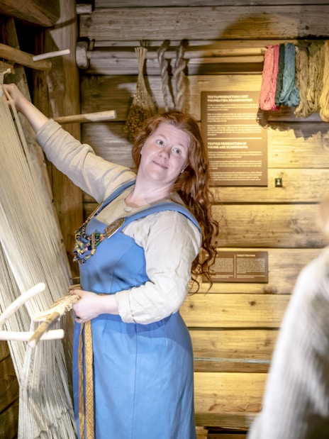 Costumed guide demonstrating weaving at The Viking Museum, Stockholm.