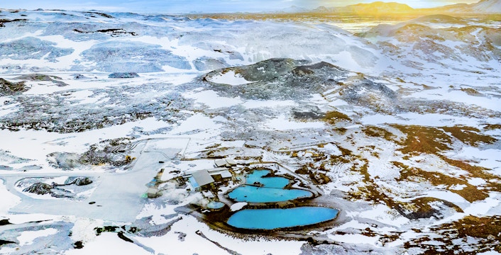 Aerial view of Myvatn Nature Baths hot spring with landscape covered with snow during sunrise