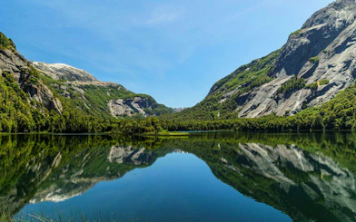 Reflections of Patagonian mountains on calm waters near Puerto Blest, Argentina.