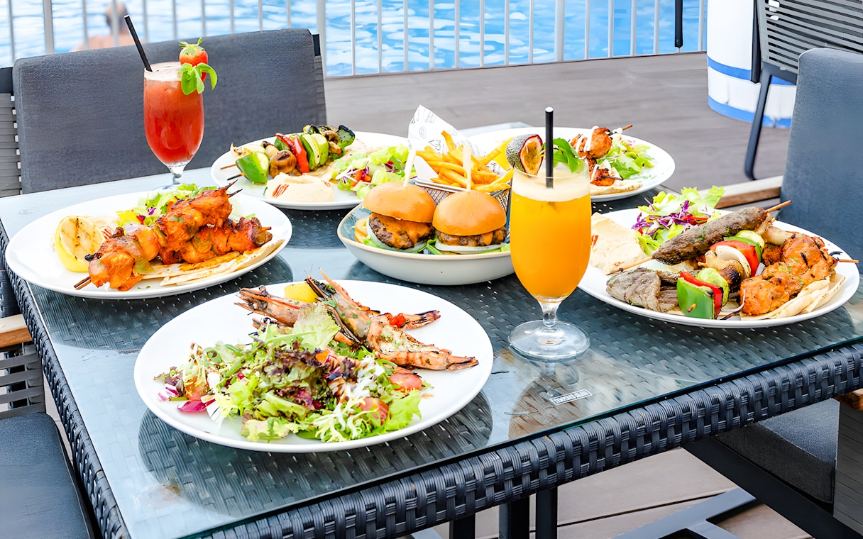 Assorted dishes and drinks on a table at Riva Beach Club, Dubai.