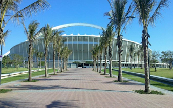 Moses Mabhida Stadium in Durban with palm-lined walkway.