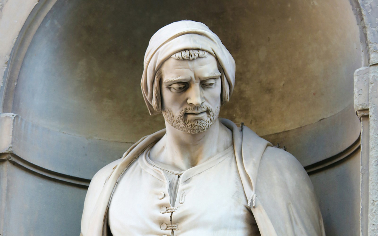 Statue of Nicola Pisano in an architectural niche, showcasing detailed craftsmanship.