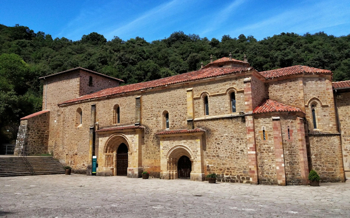Monastery of Santo Toribio de Liébana in Cantabria, Spain, with stone facade and red-tiled roof.