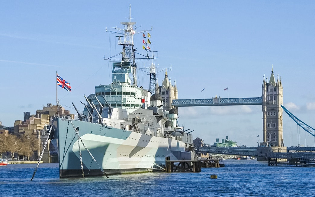 Battleship on the River Thames with Tower Bridge in the background, London.