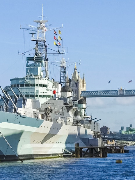 Battleship on the River Thames with Tower Bridge in the background, London.