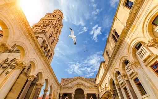 Diocletian's Palace courtyard with bell tower and seagulls in Split, Croatia.