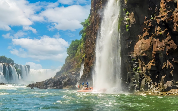 Tourists on a boat near a waterfall at Iguazú Falls, Brazilian side.