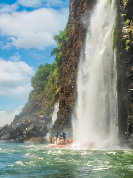 Tourists on a boat near a waterfall at Iguazú Falls, Brazilian side.