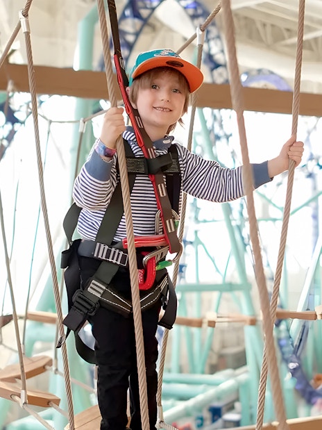 Child navigating ropes course at Legends of the Hidden Temple, American Dream, Nickelodeon Universe.