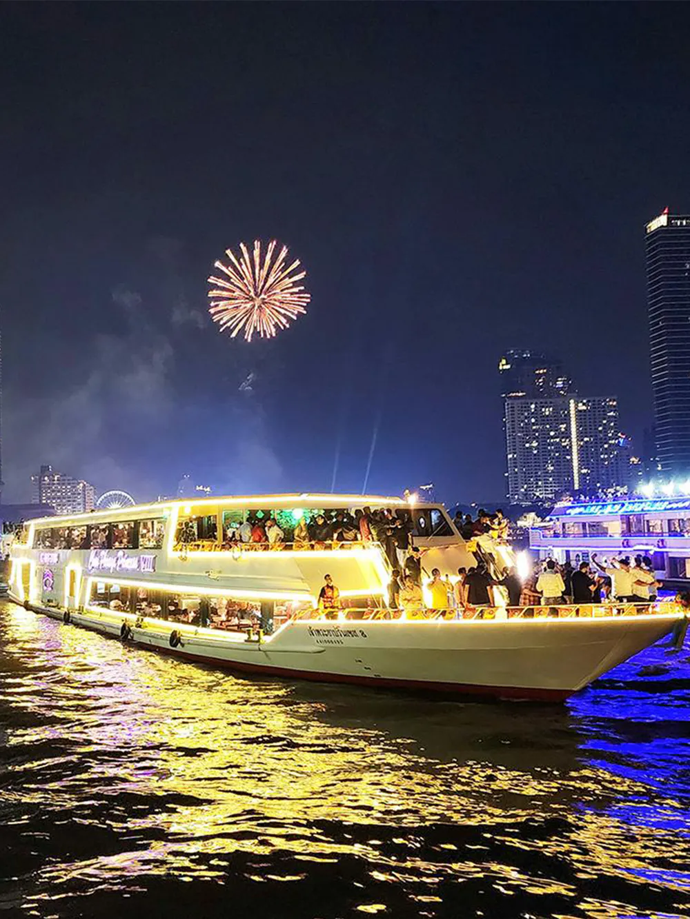 Chao Phraya Princess Cruise with fireworks over Bangkok skyline at night.