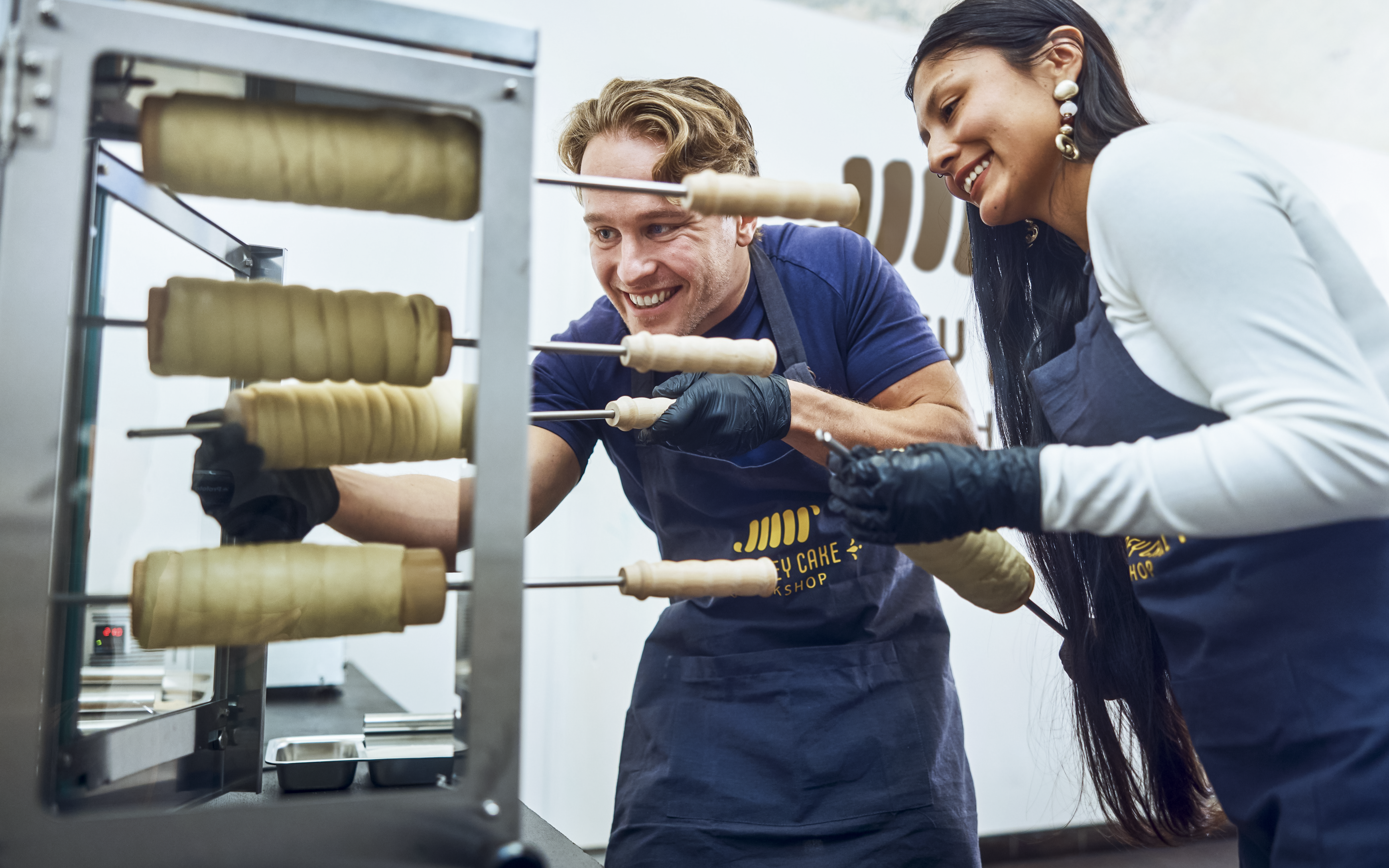 Participants making chimney cakes at a workshop in Budapest.