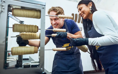 Participants making chimney cakes at a workshop in Budapest.