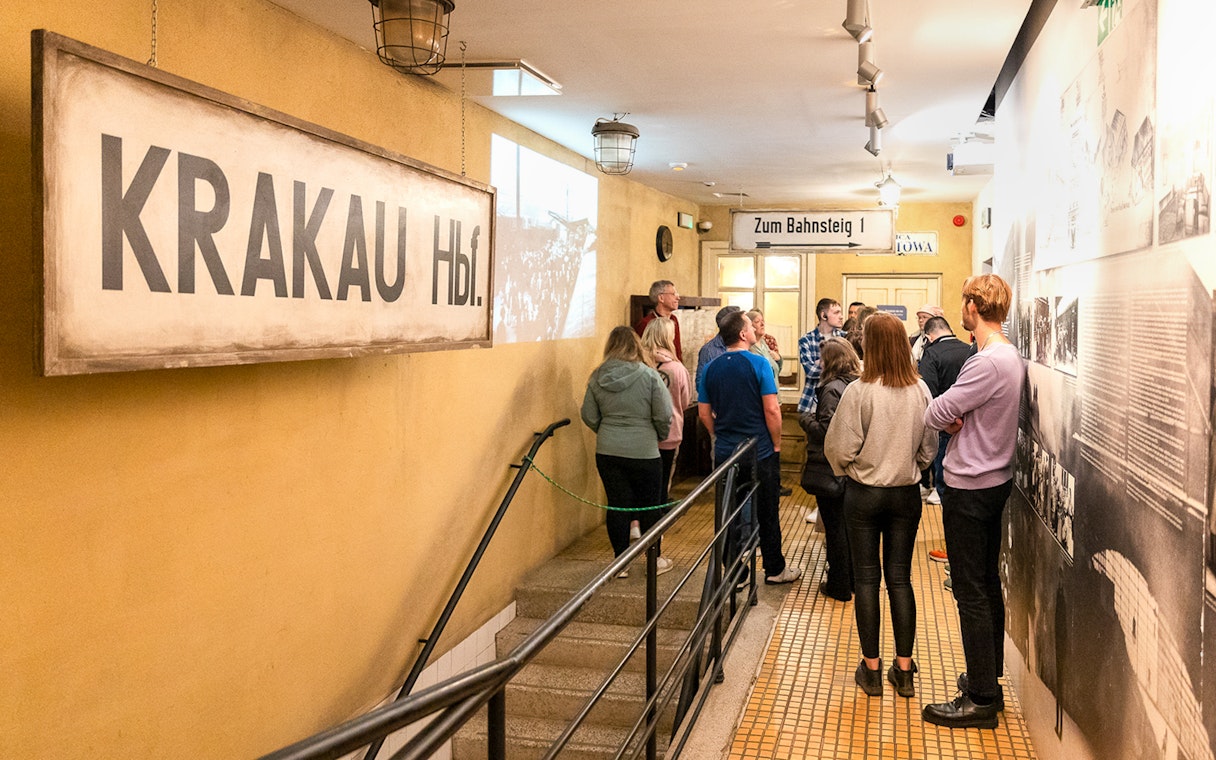 Tour group inside Oskar Schindler’s Factory, Krakow, viewing historical exhibits.