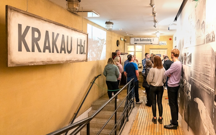Tour group inside Oskar Schindler’s Factory, Krakow, viewing historical exhibits.