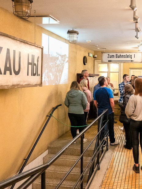 Tour group inside Oskar Schindler’s Factory, Krakow, viewing historical exhibits.