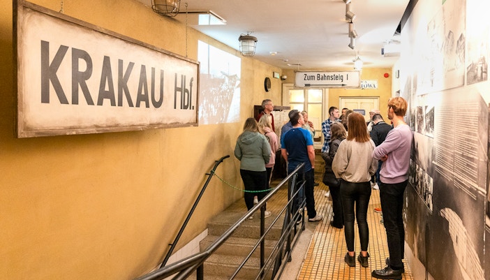 Tour group inside Oskar Schindler’s Factory, Krakow, viewing historical exhibits.