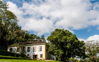 Colonial house surrounded by lush greenery in Coffee Valley, Rio de Janeiro.
