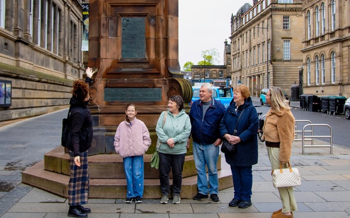 Tour group at a monument during the National Museum of Scotland guided tour in Edinburgh.