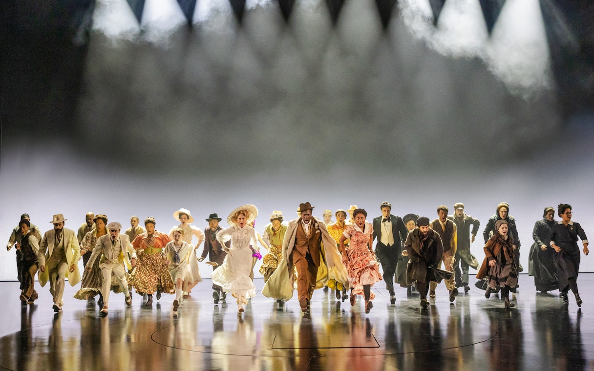 Performers in period costumes running on stage during Ragtime musical scene.