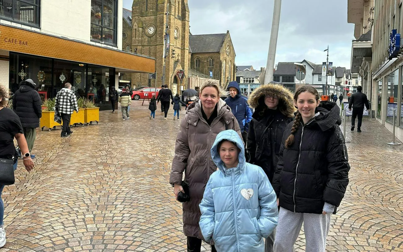 Blackpool street scene with people near a historic church, part of a self-guided city exploration game.