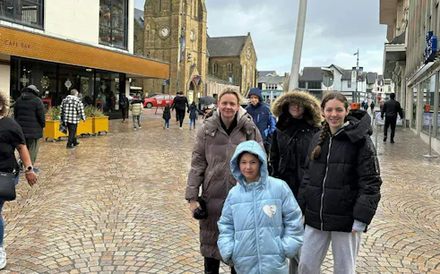 Blackpool street scene with people near a historic church, part of a self-guided city exploration game.
