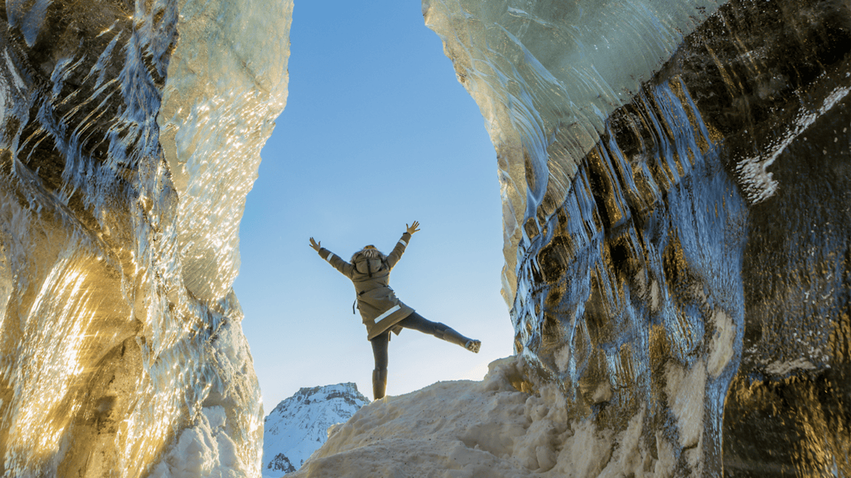 Guests exploring inside Katla Ice Cave with icy walls and snowy landscape.
