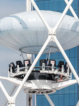 Flying Cup Dubai ride with elevated seating against a modern building backdrop.
