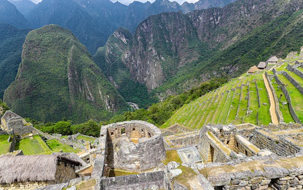 Sun Temple view point overlooking terraces and mountains at Machu Picchu, Peru.