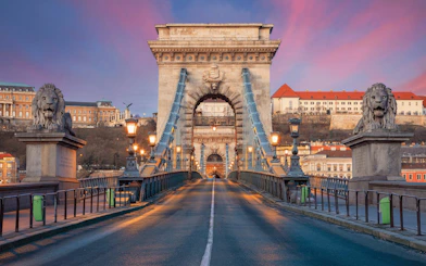 Chain Bridge in Budapest at sunset, view from road with lion statues.