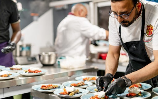 Chef preparing gourmet dishes for THEO Boat Brunch cruise in Paris.