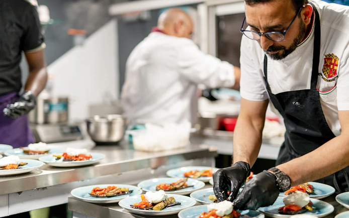 Chef preparing gourmet dishes for THEO Boat Brunch cruise in Paris.