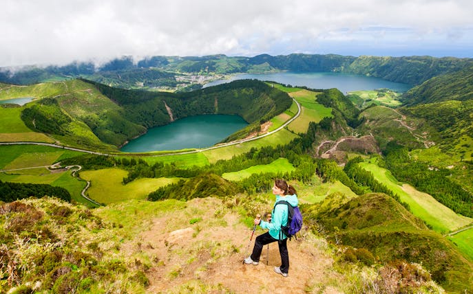 Hiker overlooking Sete Cidades crater lakes on a half-day hike in Azores, Portugal.