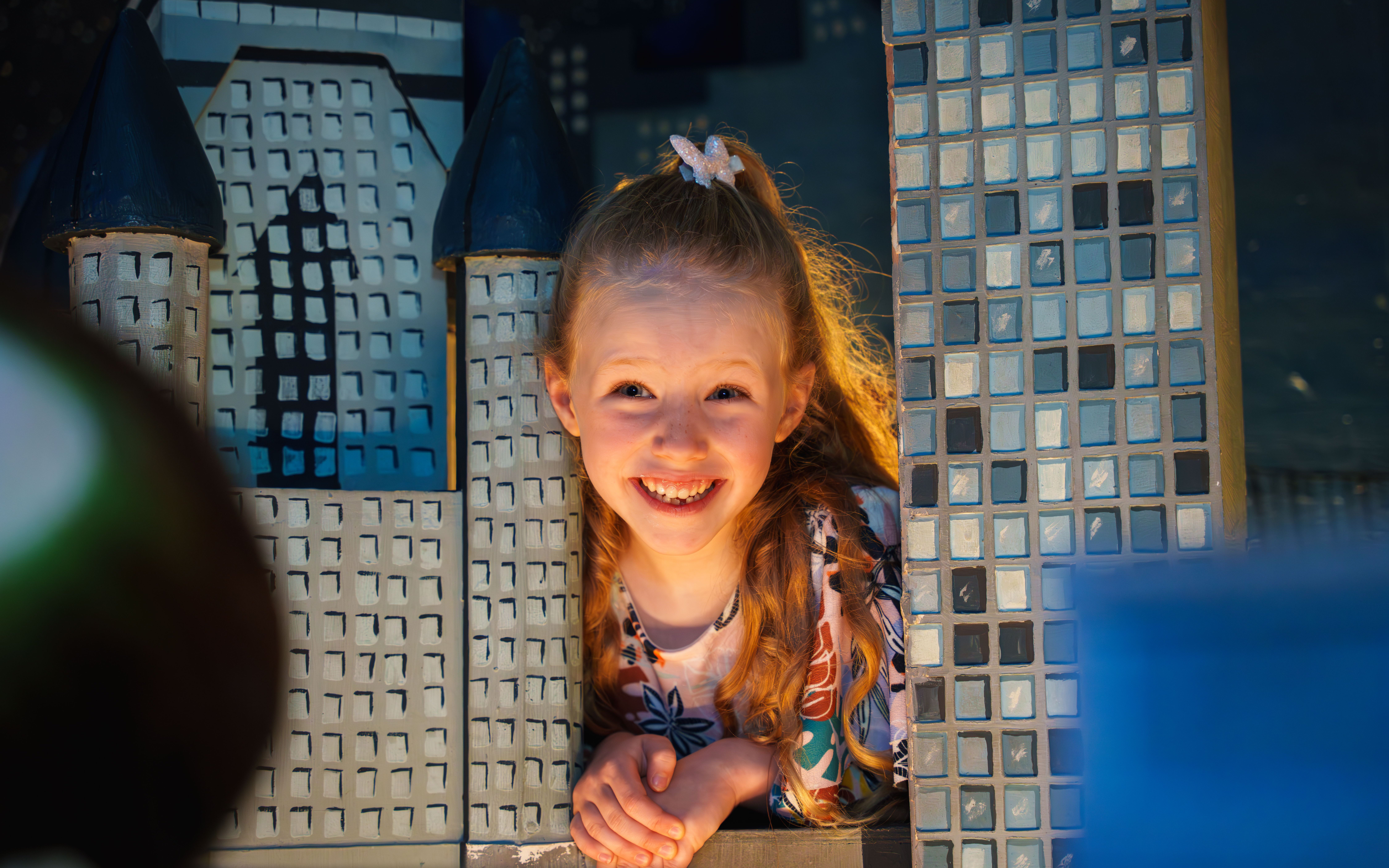 Child smiling between wax museum exhibits at the National Wax Museum.