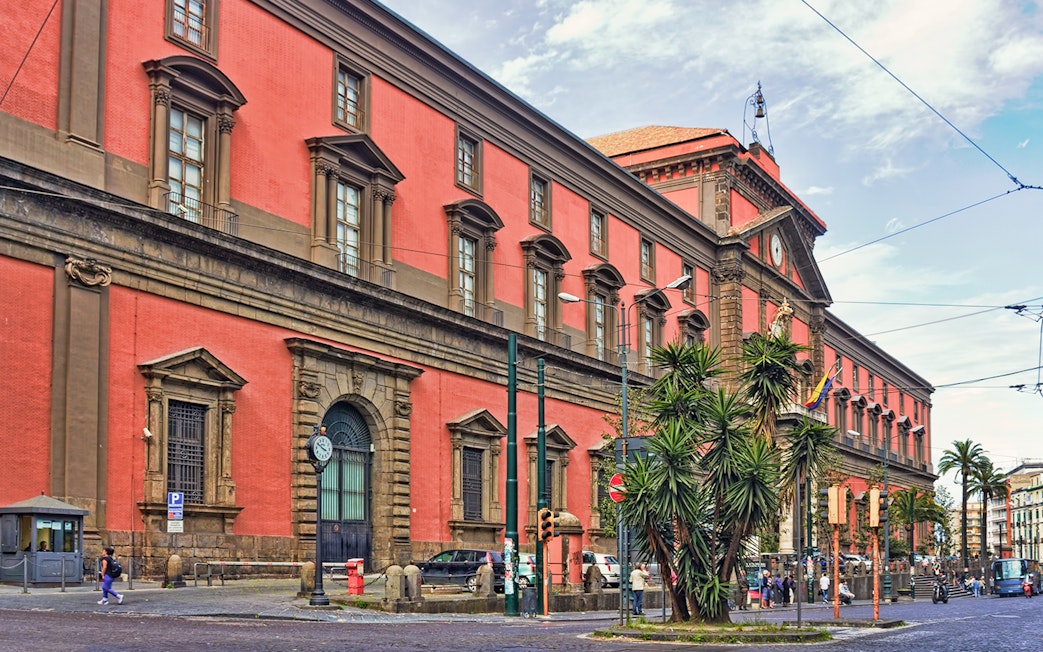 Naples National Archaeological Museum exterior with red facade and street view.