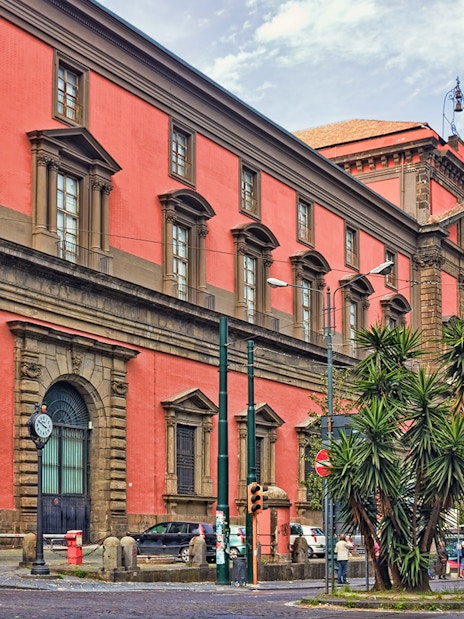 Naples National Archaeological Museum exterior with red facade and street view.