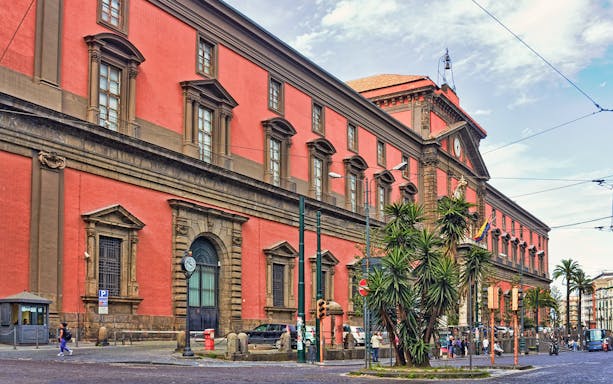 Naples National Archaeological Museum exterior with red facade and street view.
